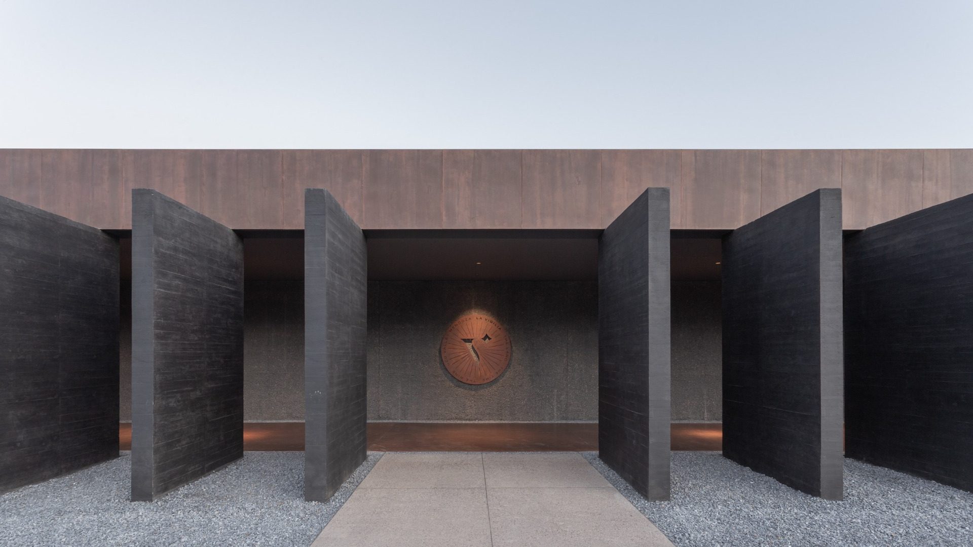 Entrance of La Vigilia Winery framed by black concrete vertical planes