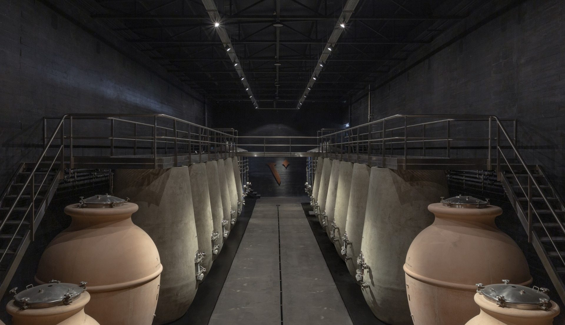 Terracotta and concrete wine vessels in the production hall of La Vigilia Winery