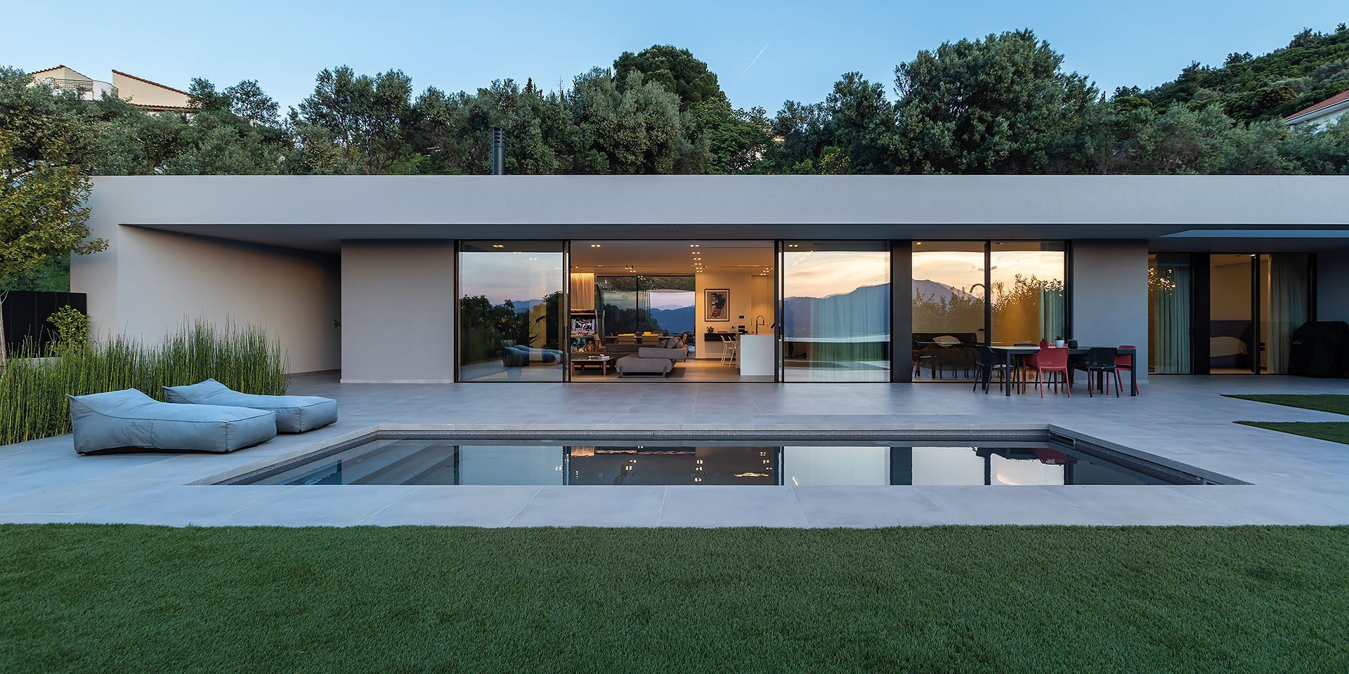 Residence in Achaia by Façade, glazed northwest elevation with pool and garden