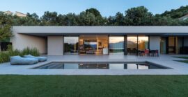 Residence in Achaia by Façade, glazed northwest elevation with pool and garden