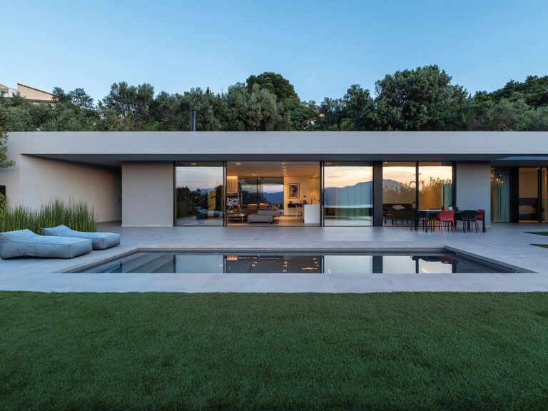 Residence in Achaia by Façade, glazed northwest elevation with pool and garden