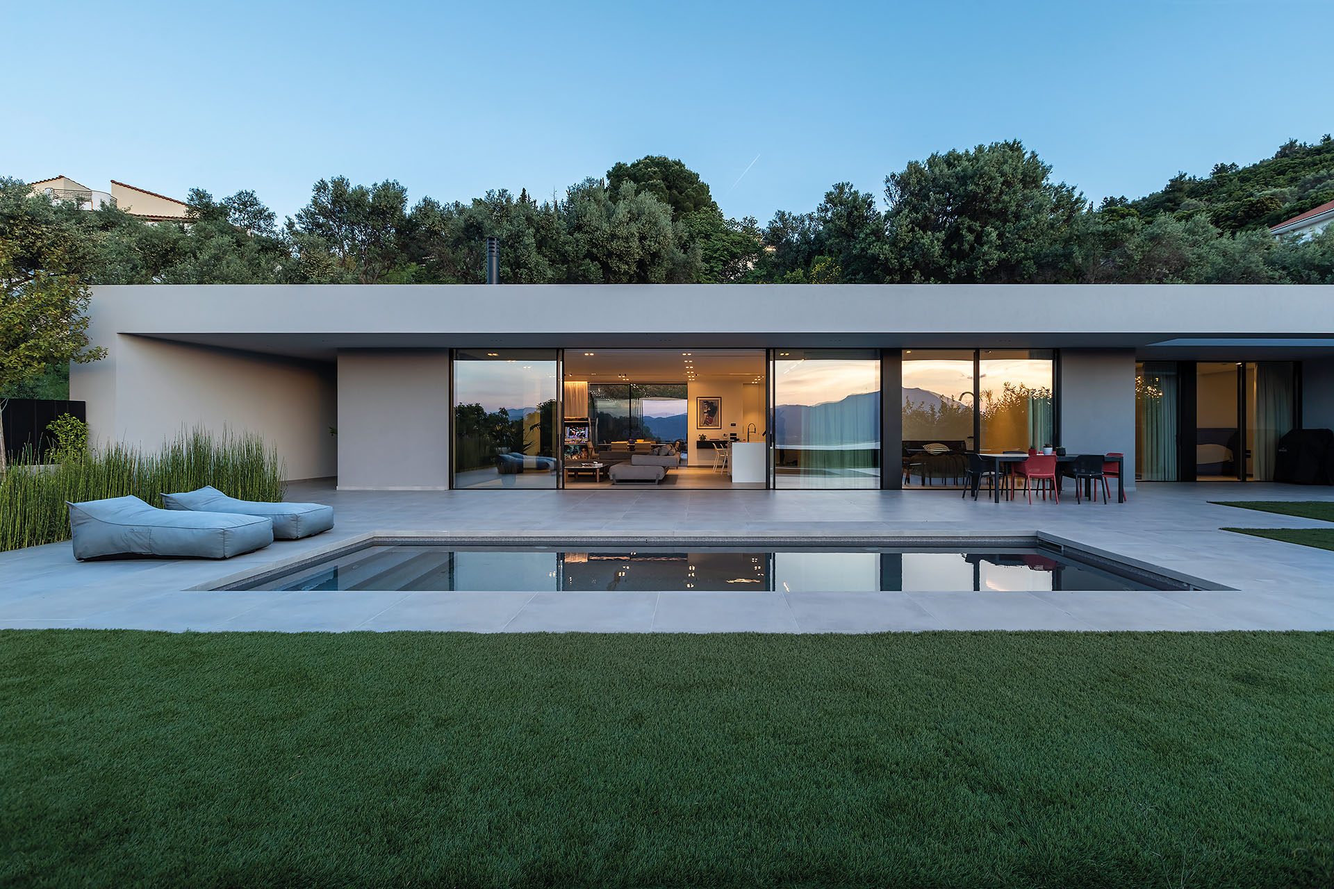 Residence in Achaia by Façade, glazed northwest elevation with pool and garden