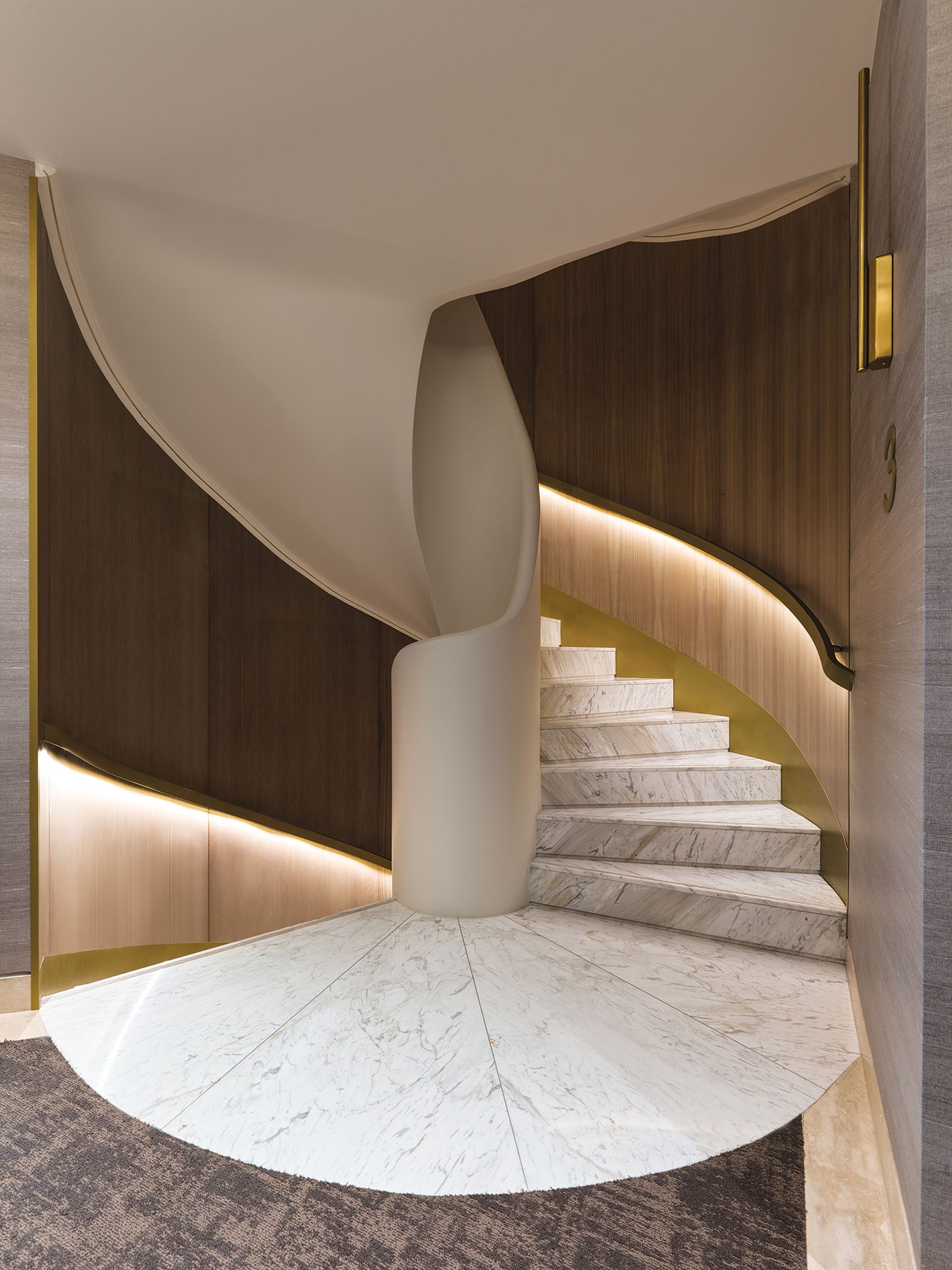 Spiral marble staircase with oak wall panels at Anthology of Athens