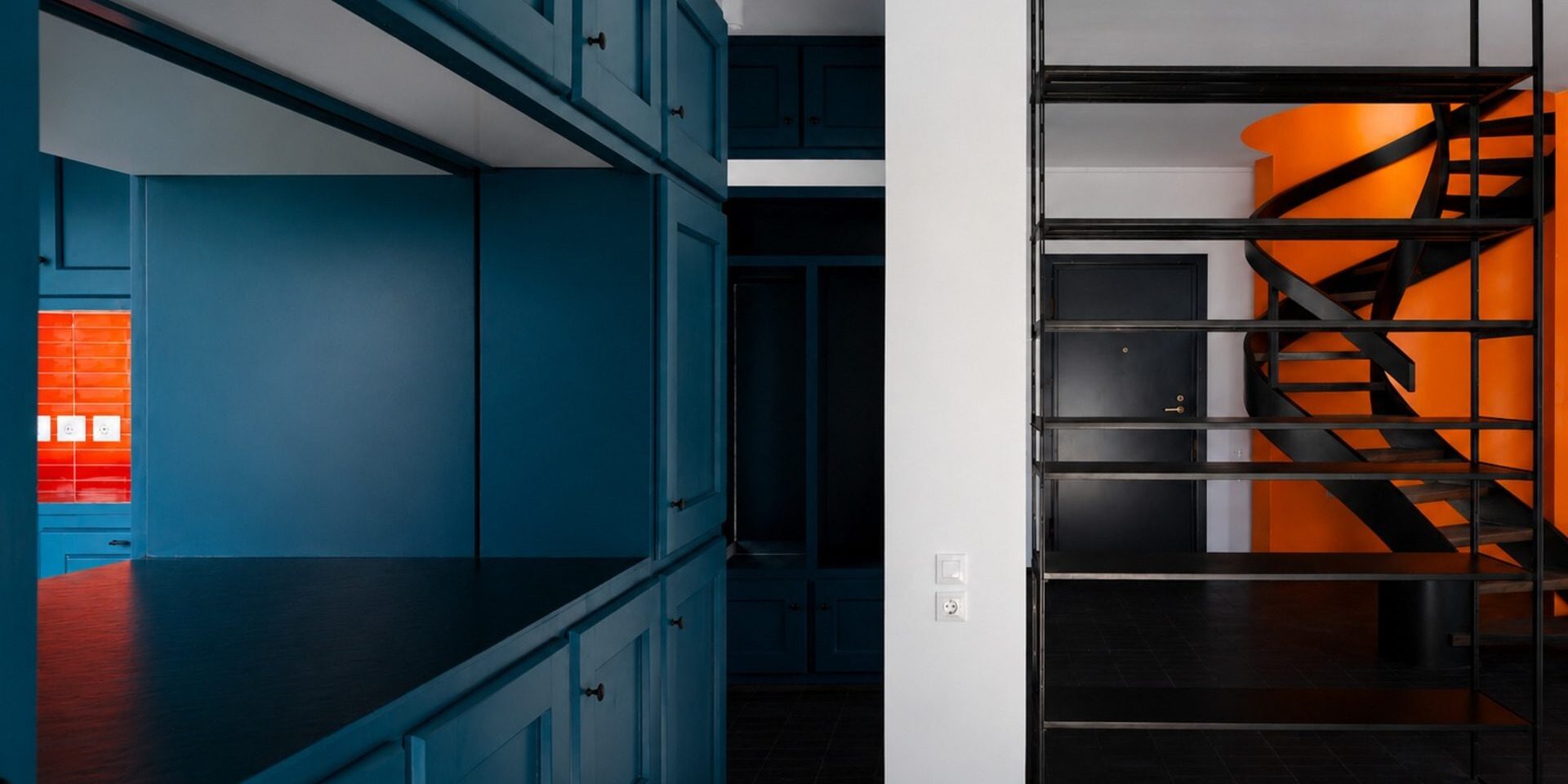 Petrol-blue cabinetry and orange spiral stair in the Duplex Residence in Athens