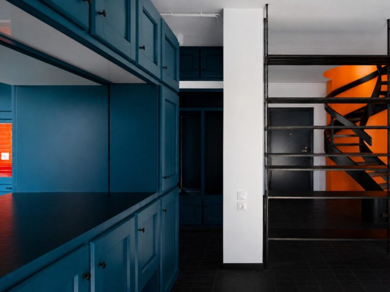 Petrol-blue cabinetry and orange spiral stair in the Duplex Residence in Athens