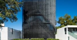 Torre Negra black metal-screened façade behind planted entrance strip