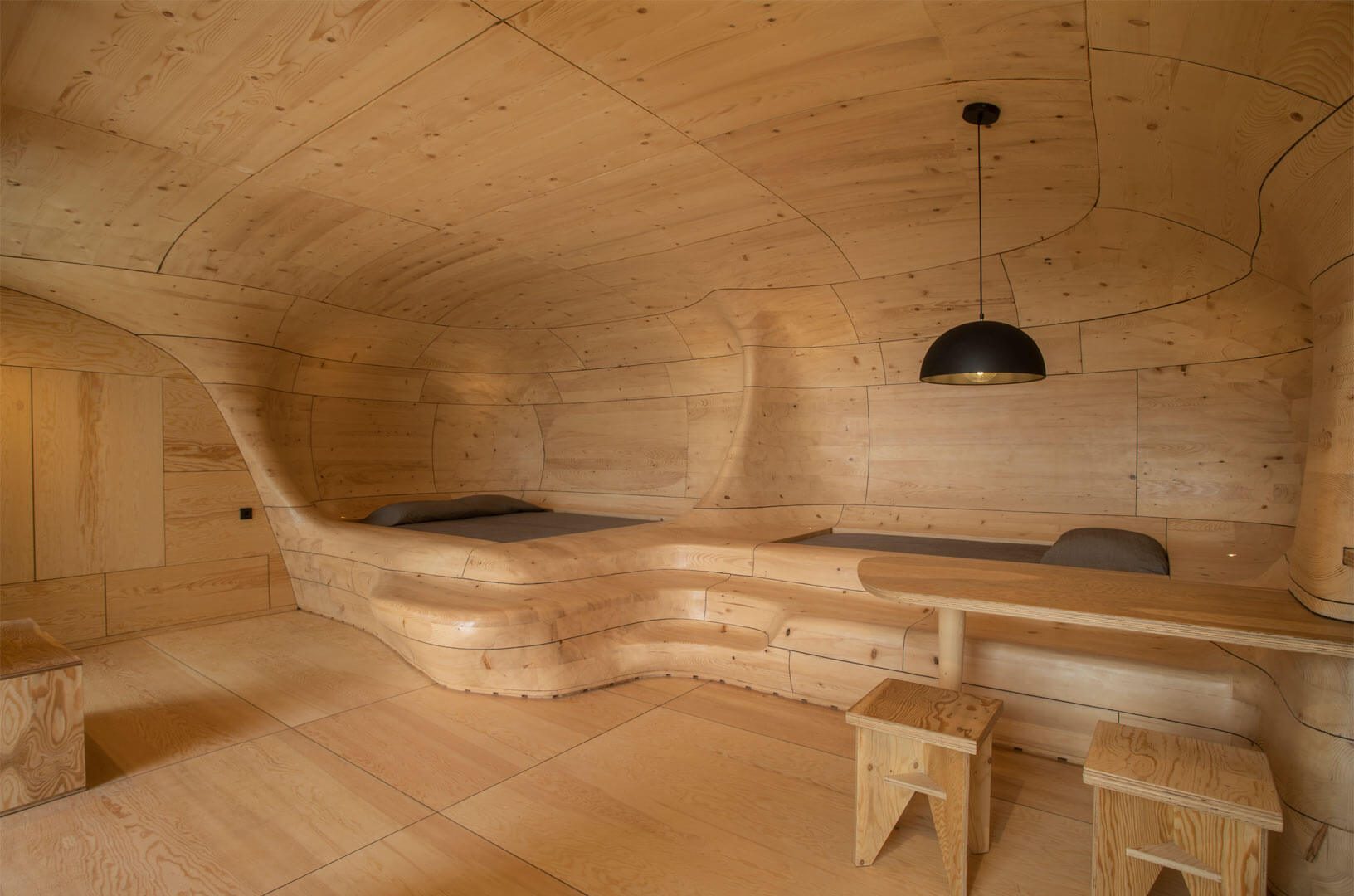 Sleeping platforms within the curved timber enclosure of The Wooden Cave