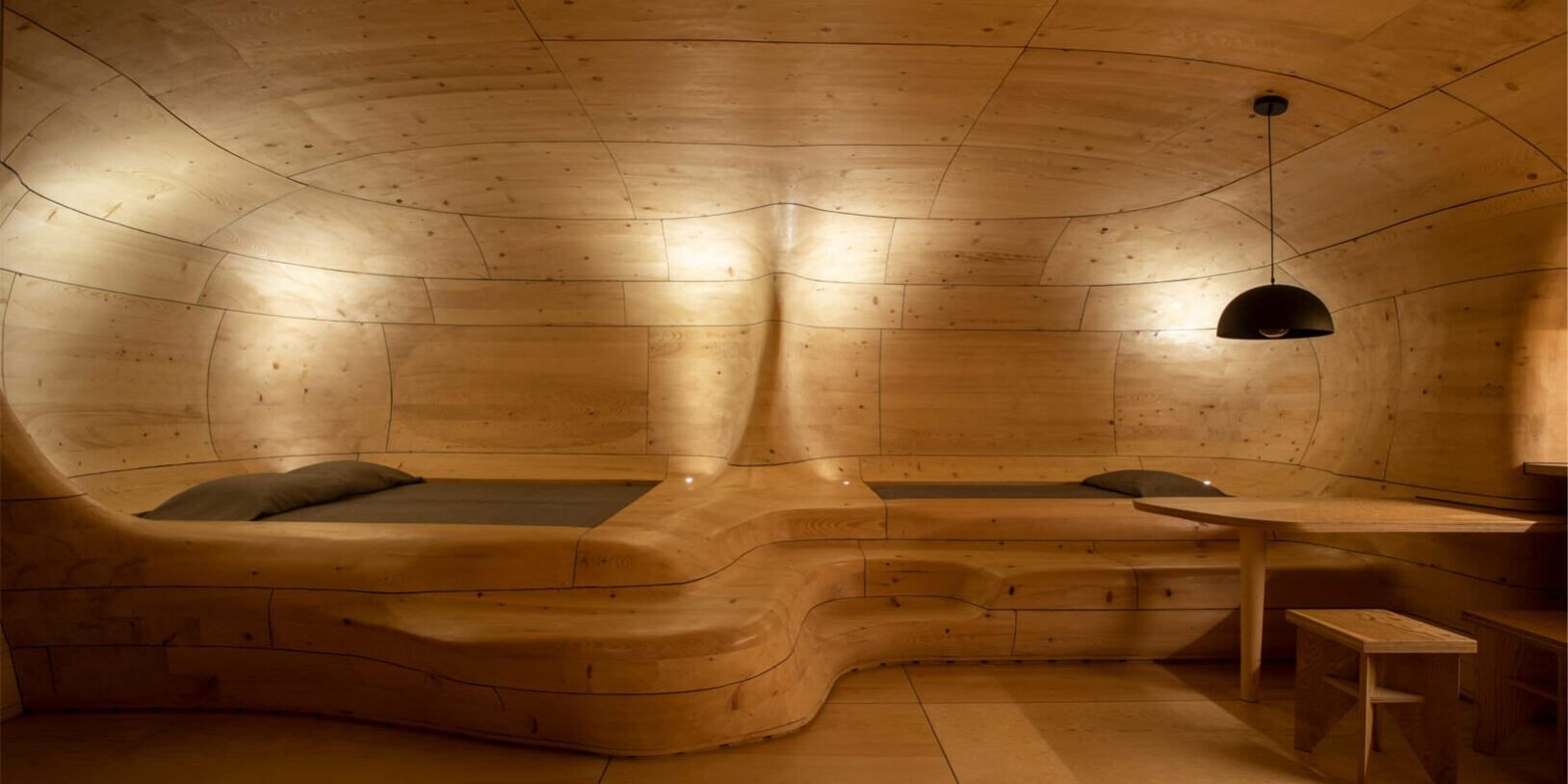 06-ek-magazine-articles-Wooden-Cave-web Curved timber structure with integrated sleeping platforms in The Wooden Cave