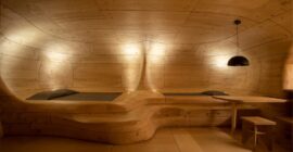 Curved timber structure with integrated sleeping platforms in The Wooden Cave