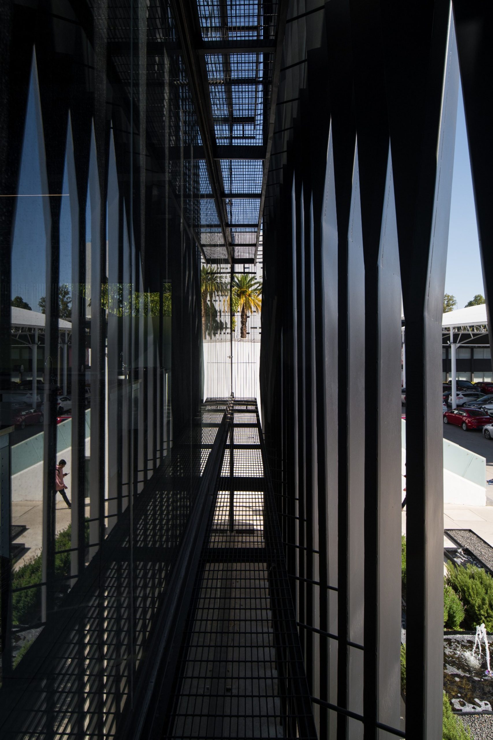 Circulation walkway behind metal slats at Torre Negra