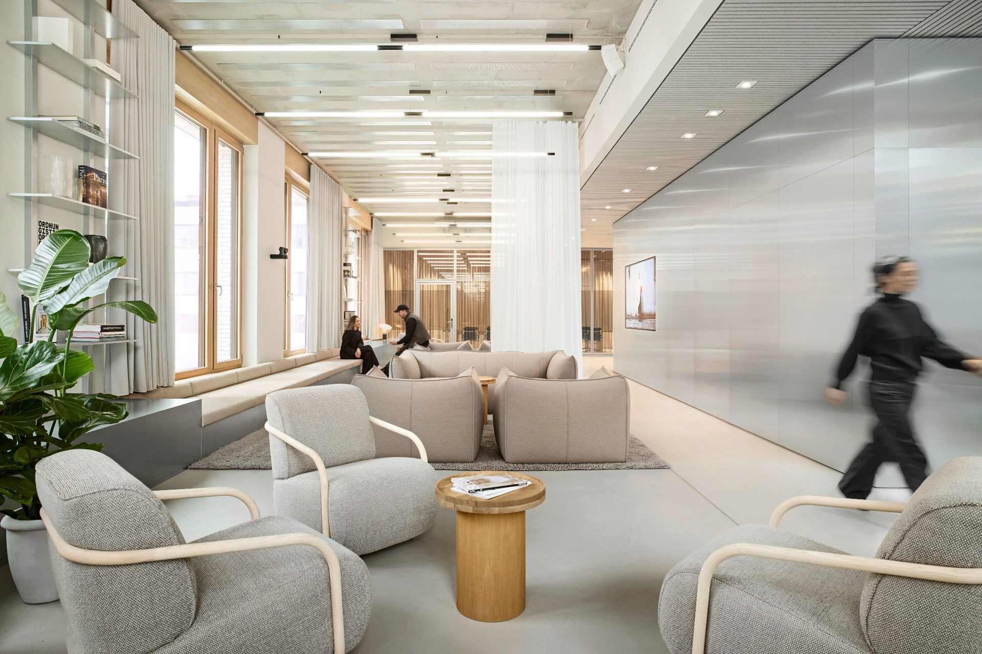 BESTSECRET offices Munich lounge with grey armchairs, timber window frames and mirrored wall
