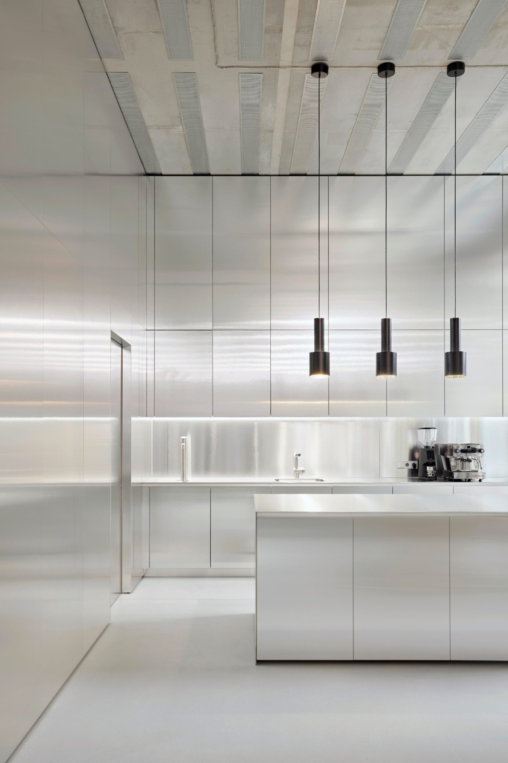 Coffee bar with stainless steel counter and pendant lights at BESTSECRET offices Munich