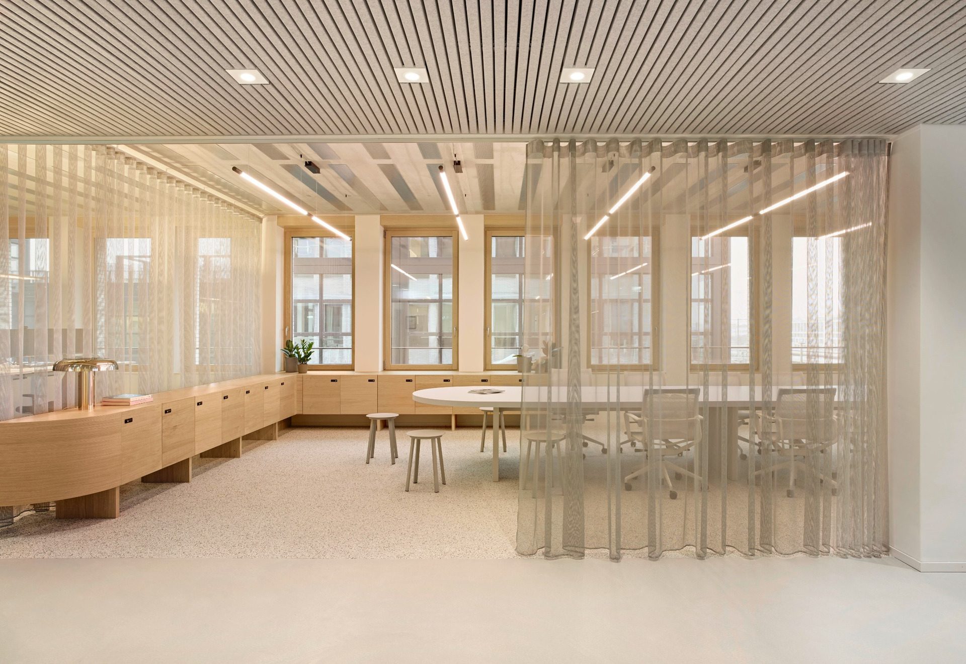 Workspace divided by metallic mesh curtains under timber ceiling at BESTSECRET offices Munich