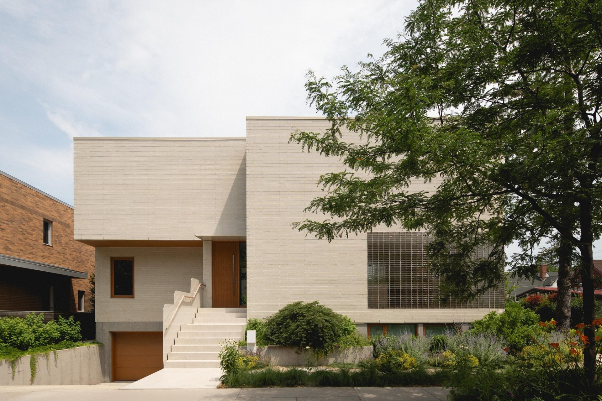 Street façade of The Lens with sunken garage and entrance steps