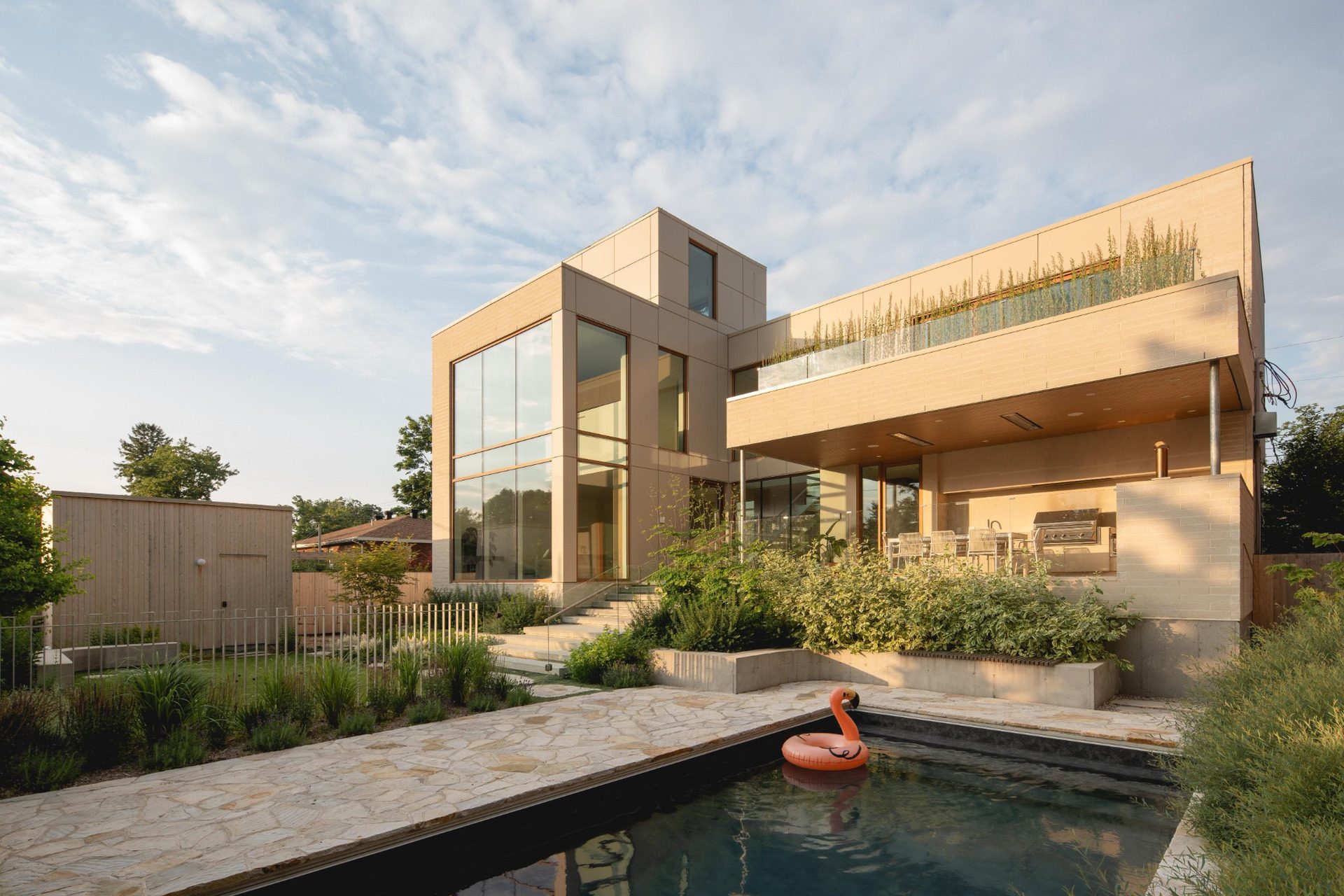 Rear façade of The Lens with covered terrace and dark-bottomed pool