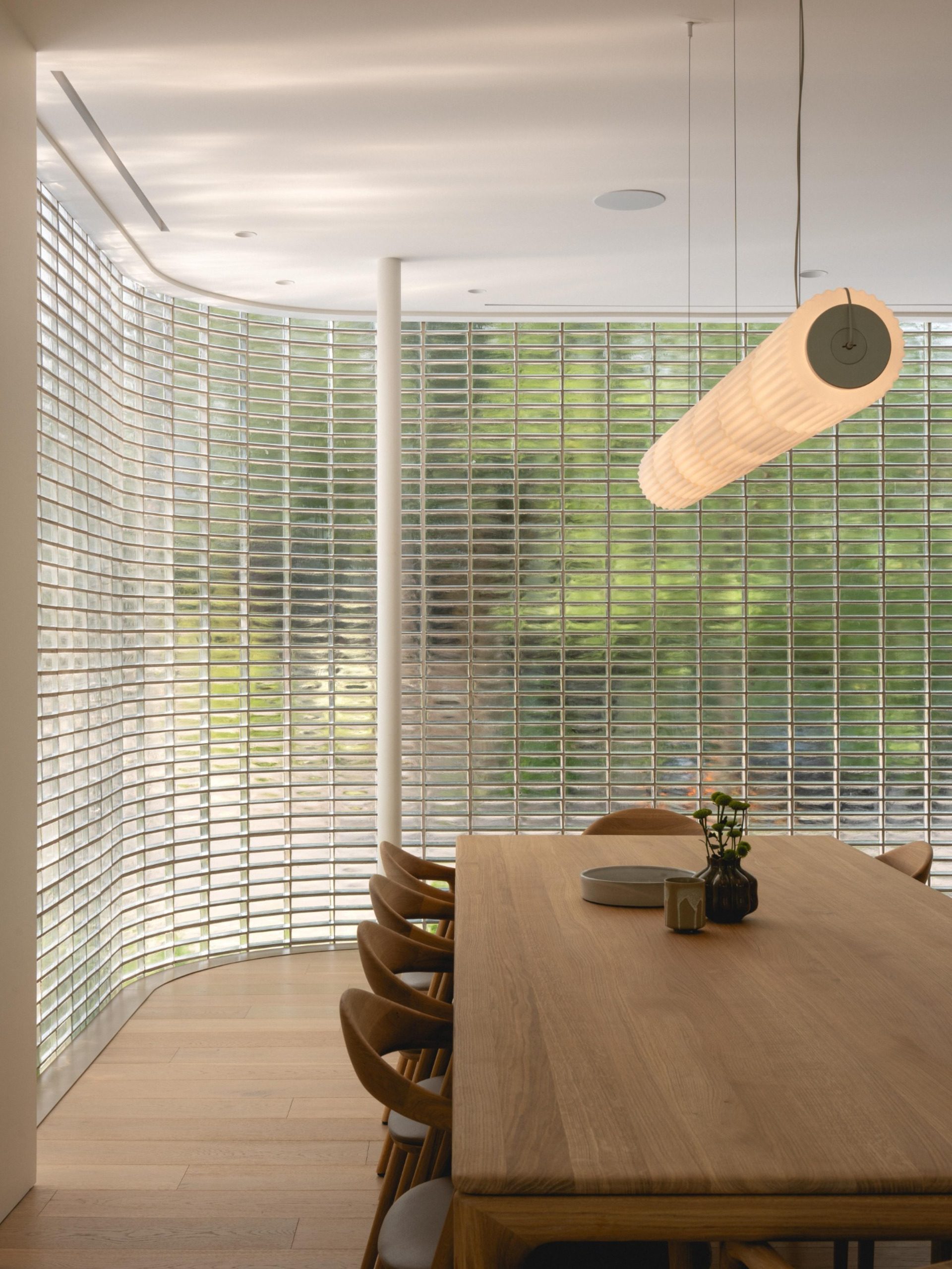 Dining table beside the curved glass-block wall at The Lens
