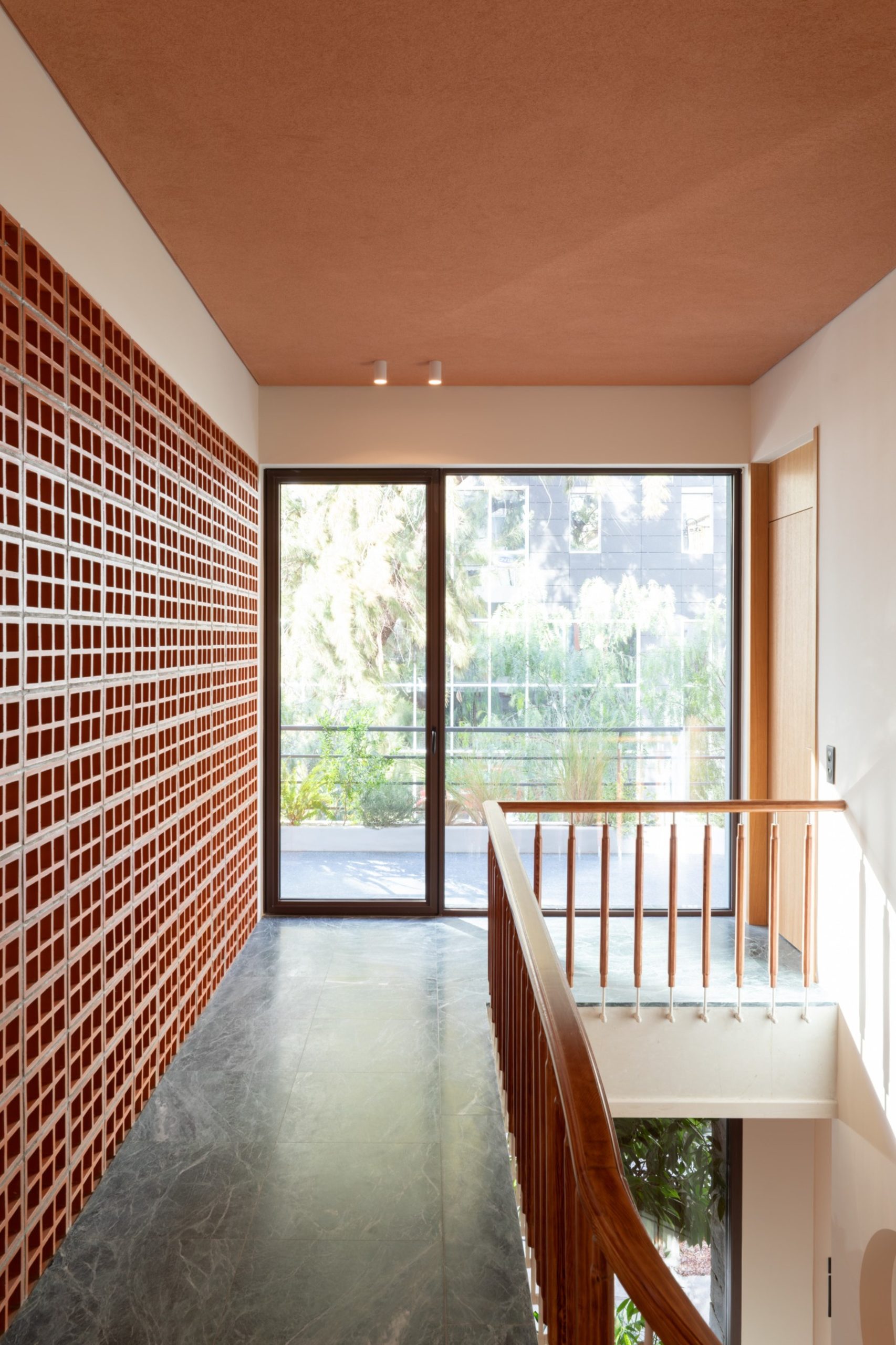 Upper floor landing with claustra wall and balcony door in Chalandri residence