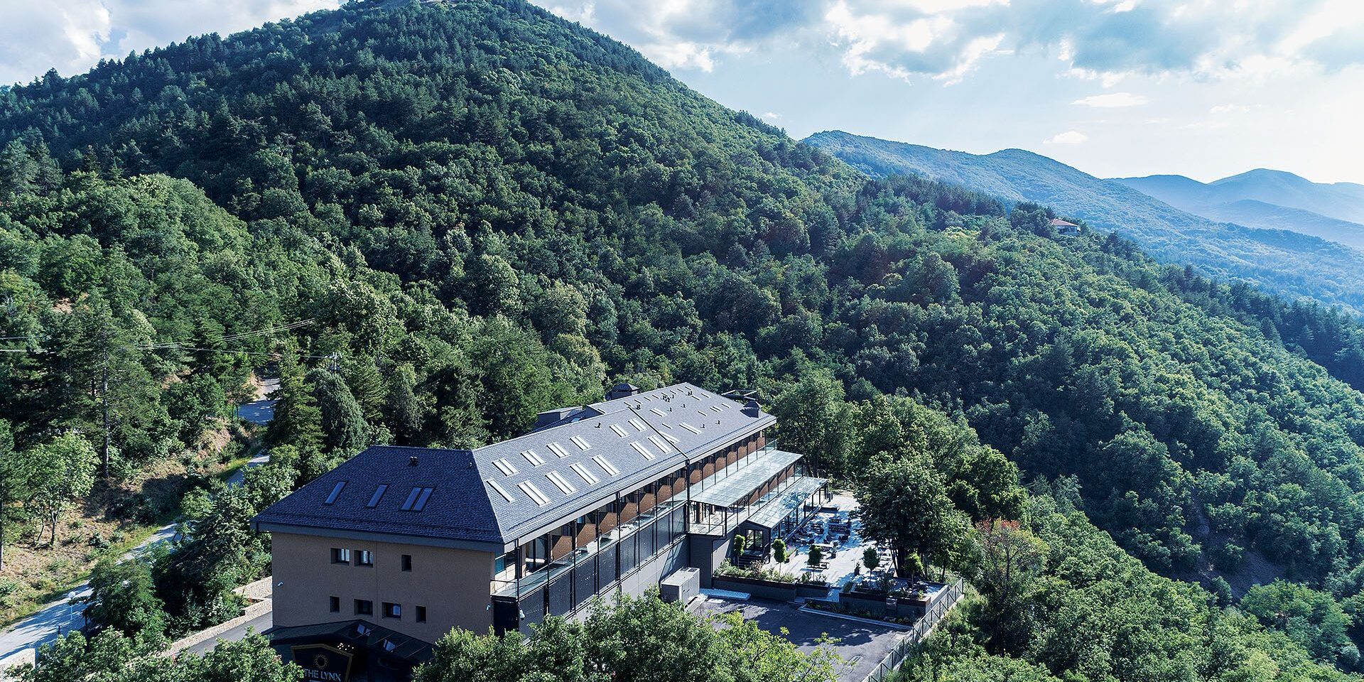 Aerial view of The Lynx Mountain Resort on a forested hill above Florina