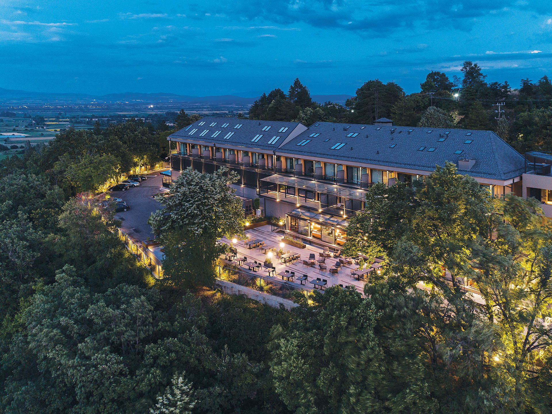 The Lynx Mountain Resort and its lit terraces among trees at dusk