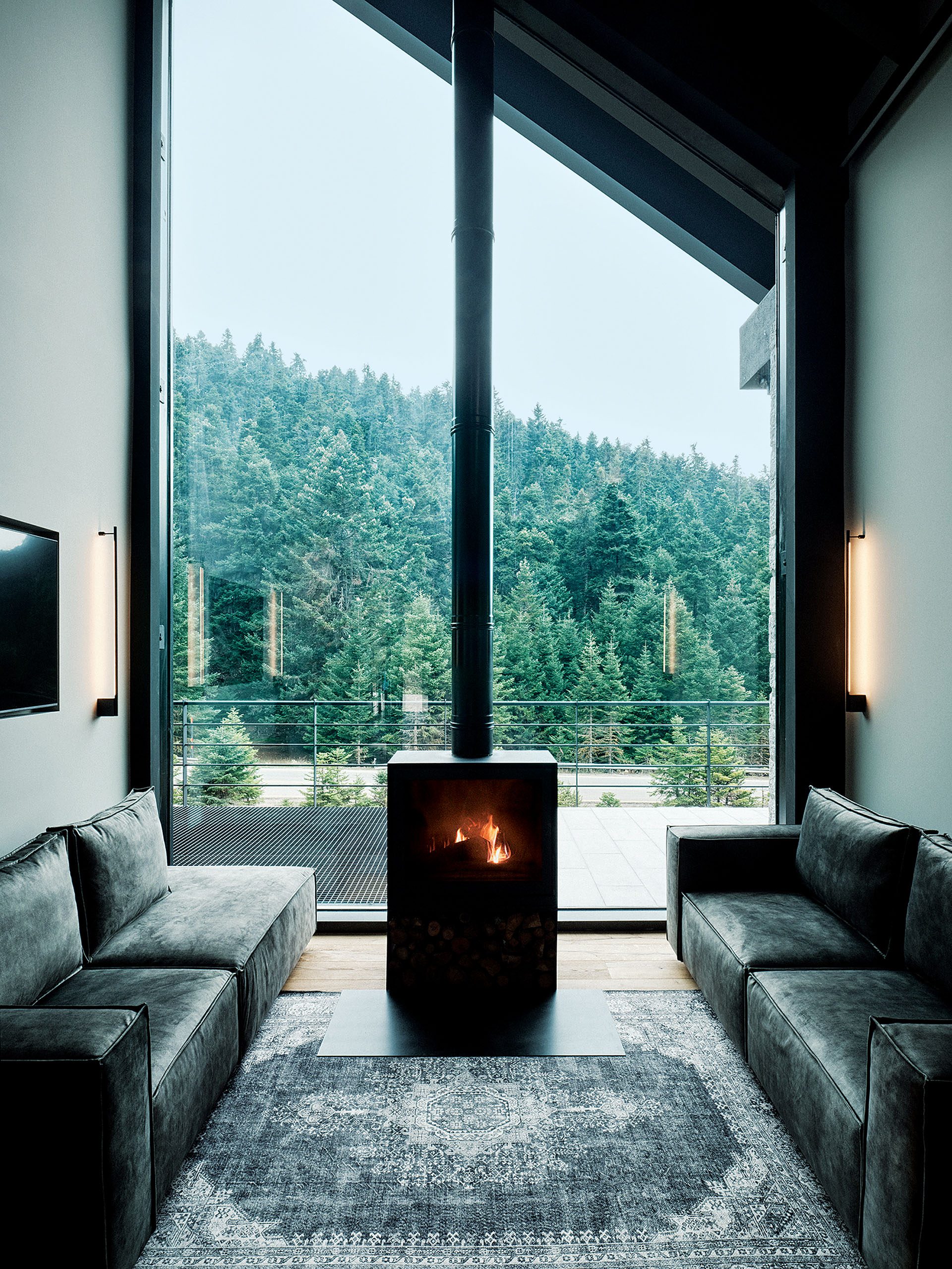 Living room with stove and full-height glazing at Hermitage 1310