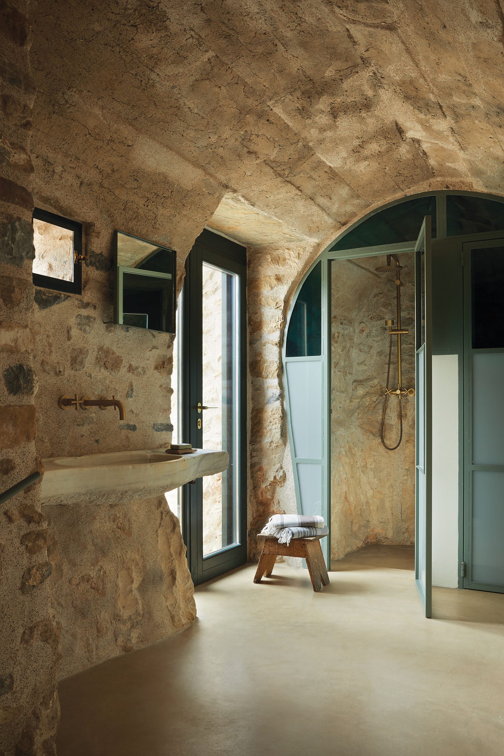 Vaulted stone bathroom beside the pool at Paratiritirio