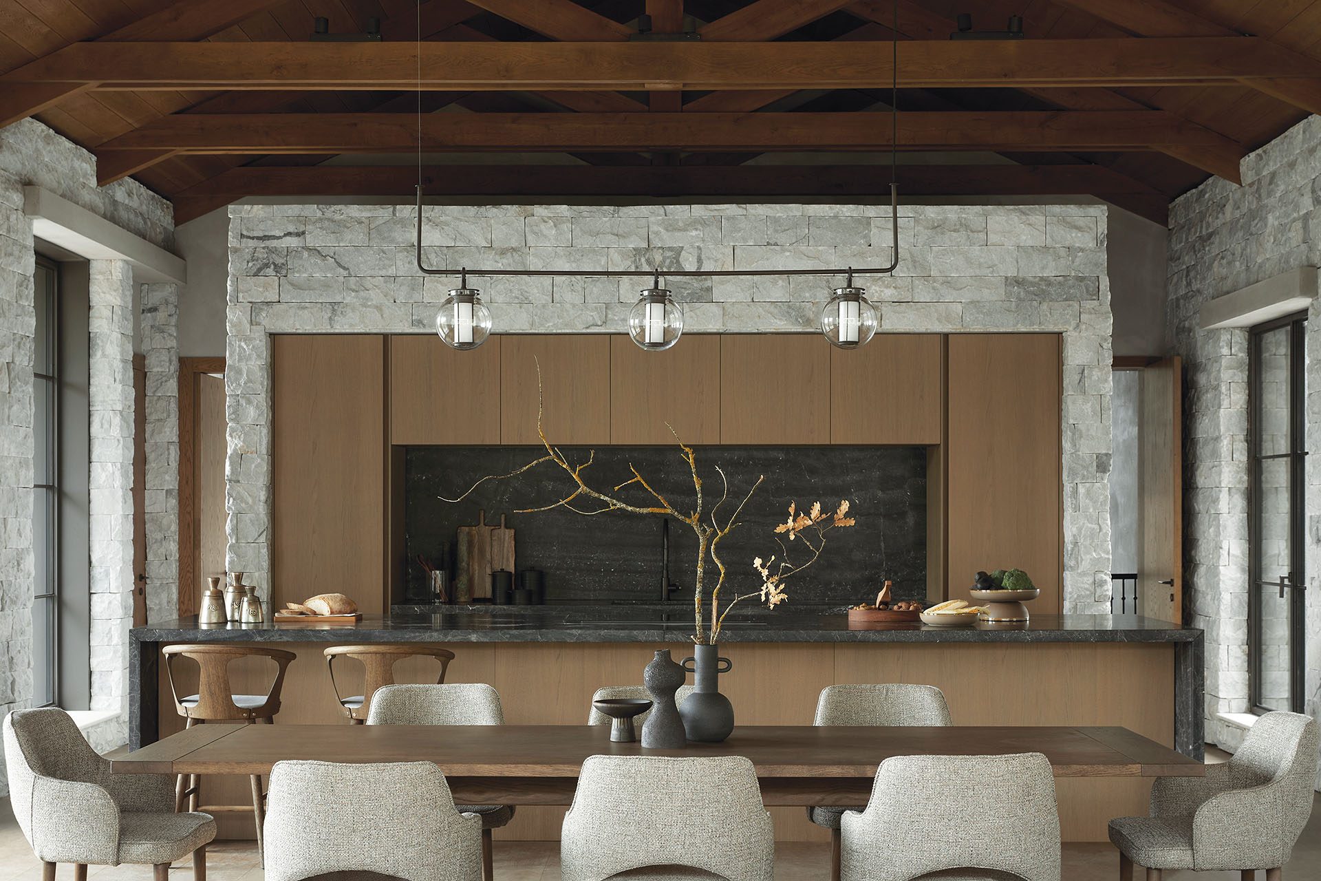 Dining area and timber kitchen under exposed beams at Patrion House