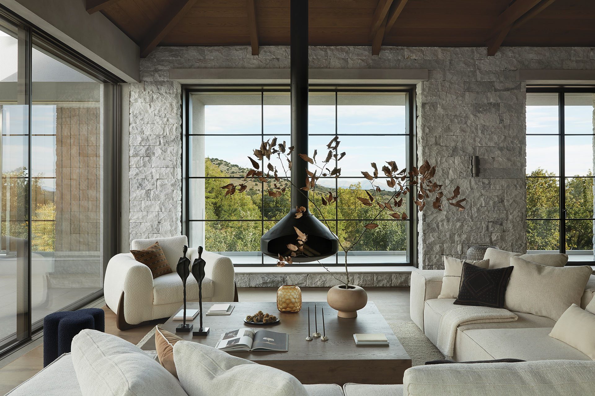 Living area with suspended cast-iron fireplace at Patrion House