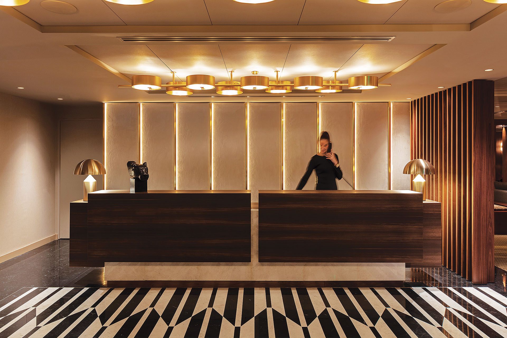 Reception with walnut panelling and patterned floor at The Lynx Mountain Resort