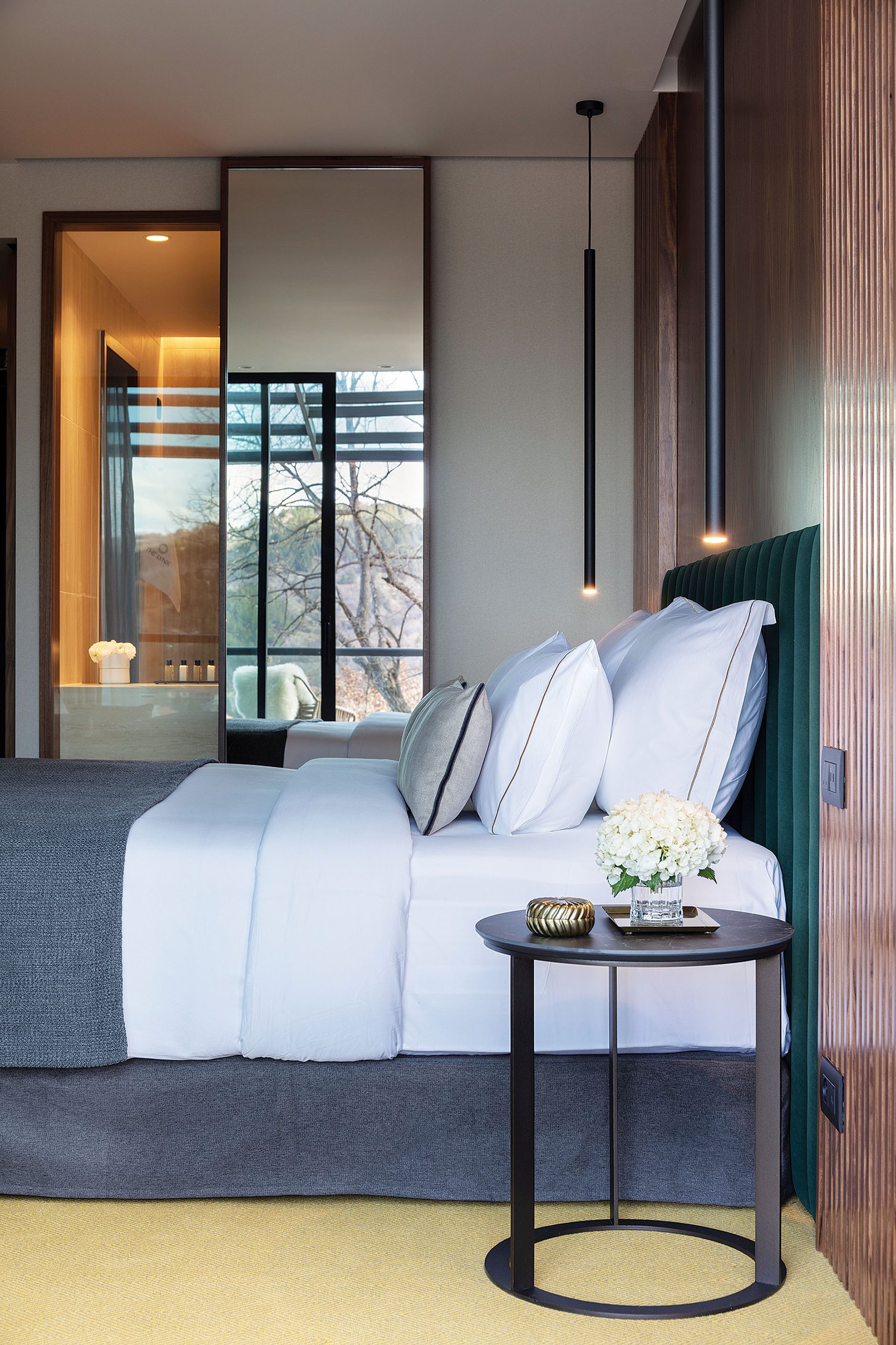 Guestroom bed with walnut headboard at The Lynx Mountain Resort