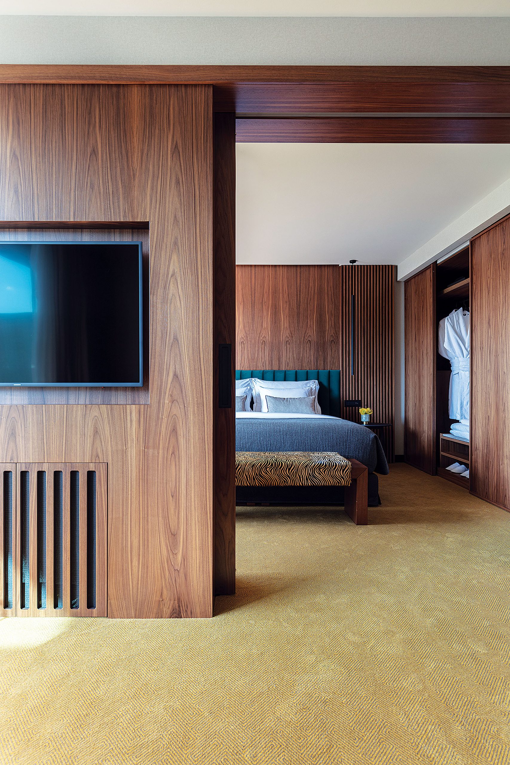 Suite with walnut partition and bedroom beyond at The Lynx Mountain Resort