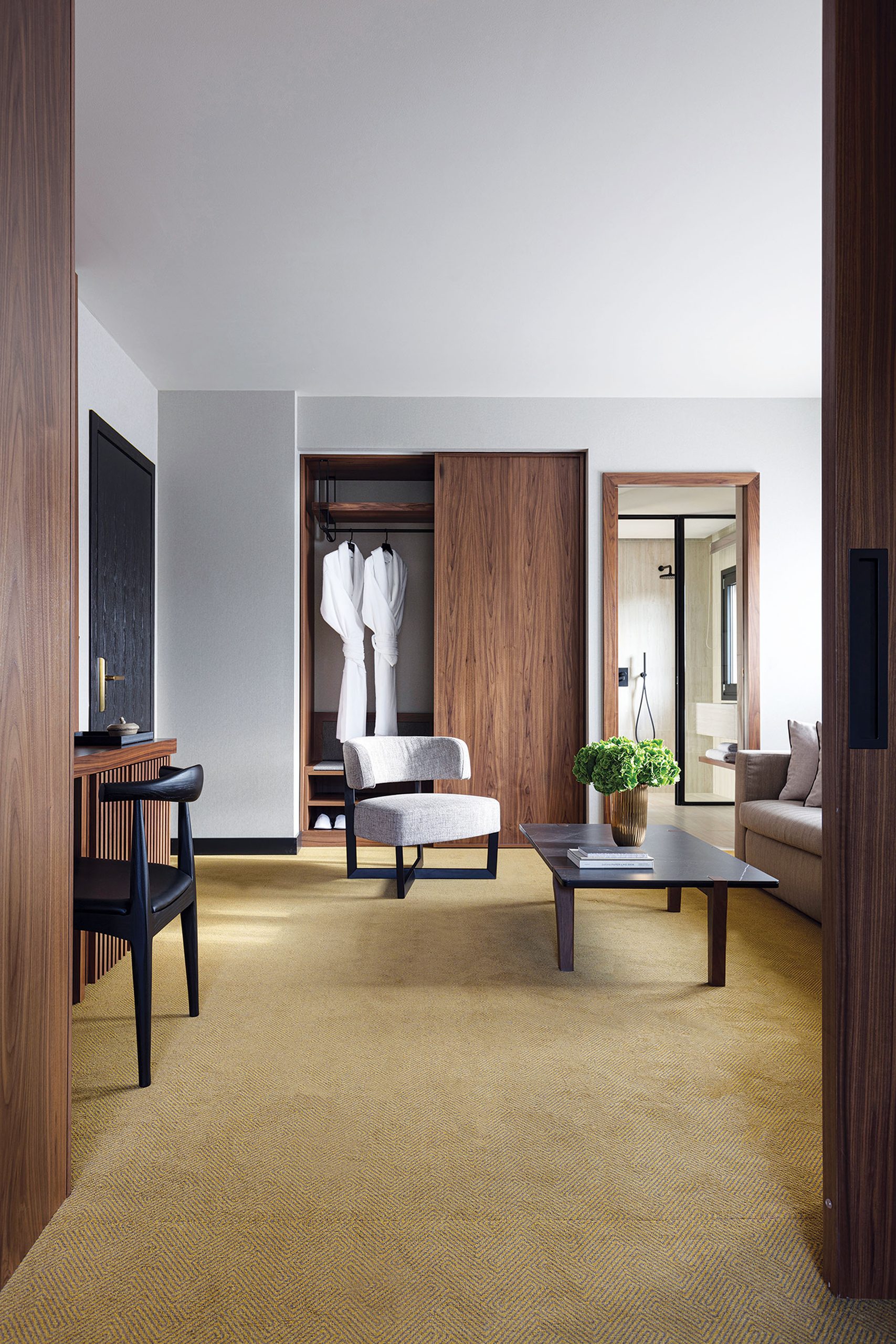 Guestroom seating area with walnut joinery at The Lynx Mountain Resort