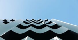 Undulating white façade of The Social Athens Hotel against the sky