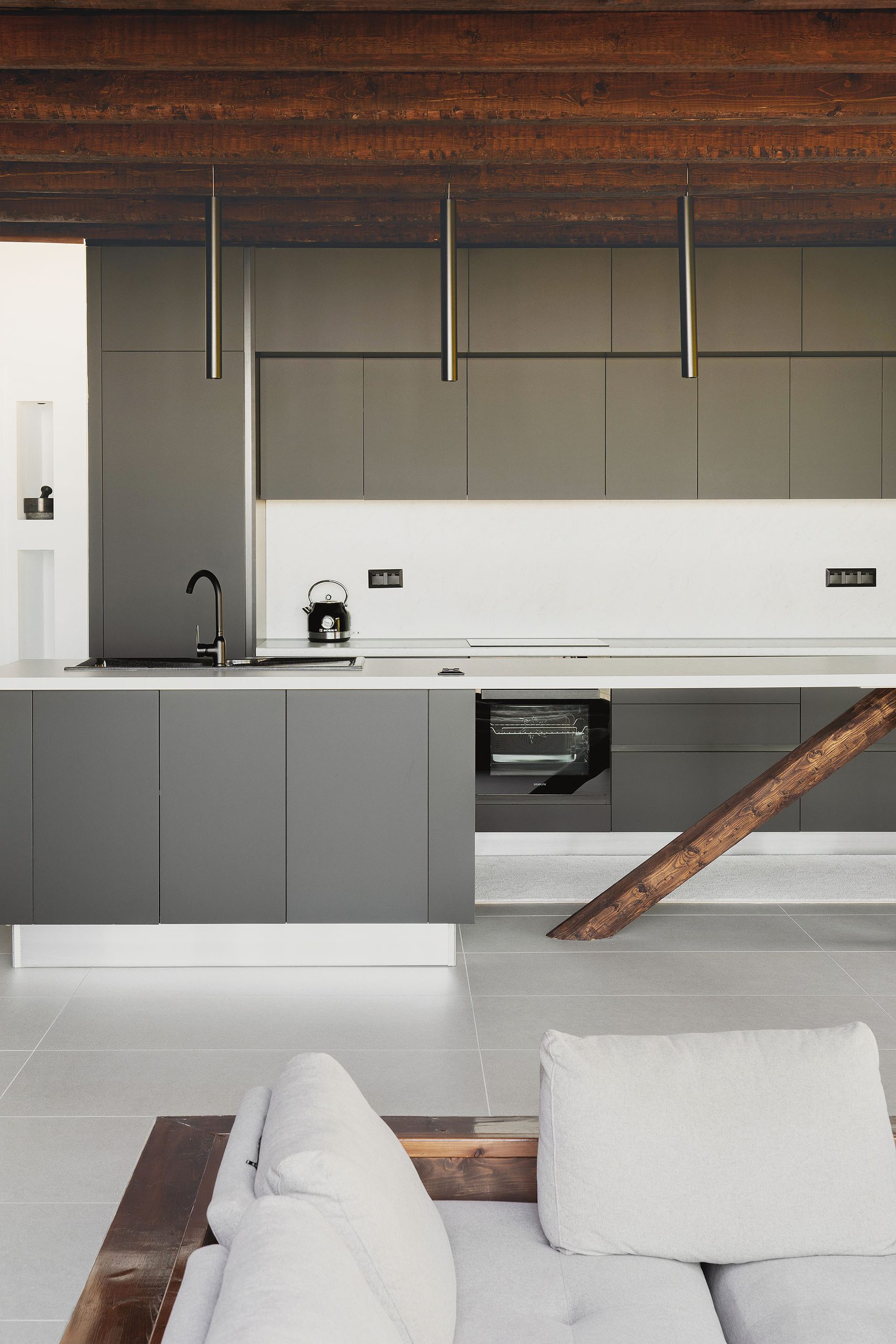Kitchen and living area under timber beams at Slope